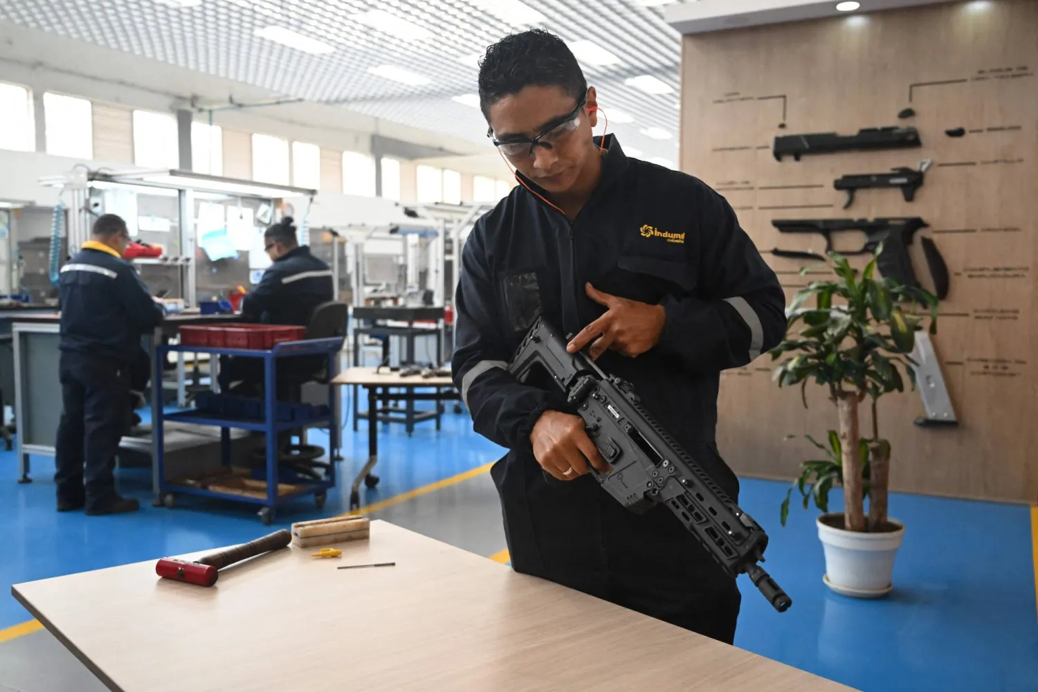 An engineer shows a new rifle designed and manufactured in the country by INDUMIL (Military Industry) at the Jose Maria Cordova Arms and Ammunition Factory in Soacha municipality, near Bogota on September 29, 2025. (Photo by Raul ARBOLEDA / AFP)