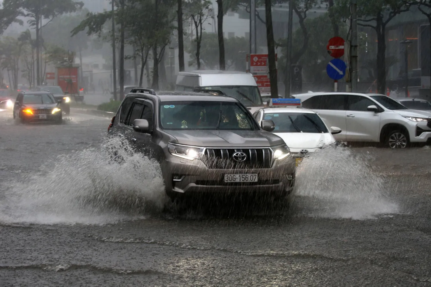 Cars drive through a flooded street in Hanoi, Vietnam, 30 September 2025. (EPA)