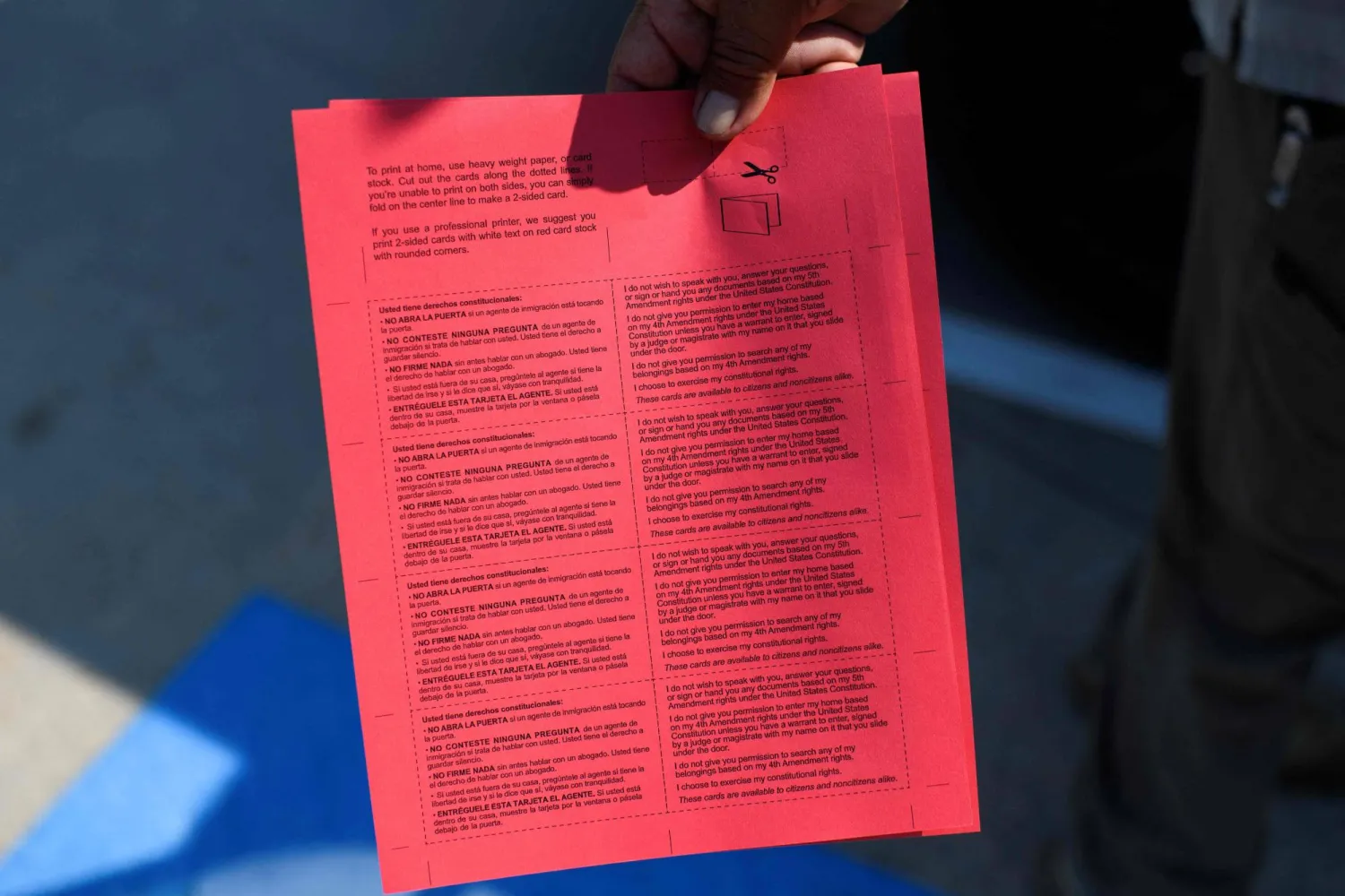 ناشط من «التحالف اللاتيني الدولي» لحقوق المهاجرين يرفع منشوراً حول تتبع عمليات إدارة الهجرة والجمارك الأميركية في هيوستن (أ.ف.ب)