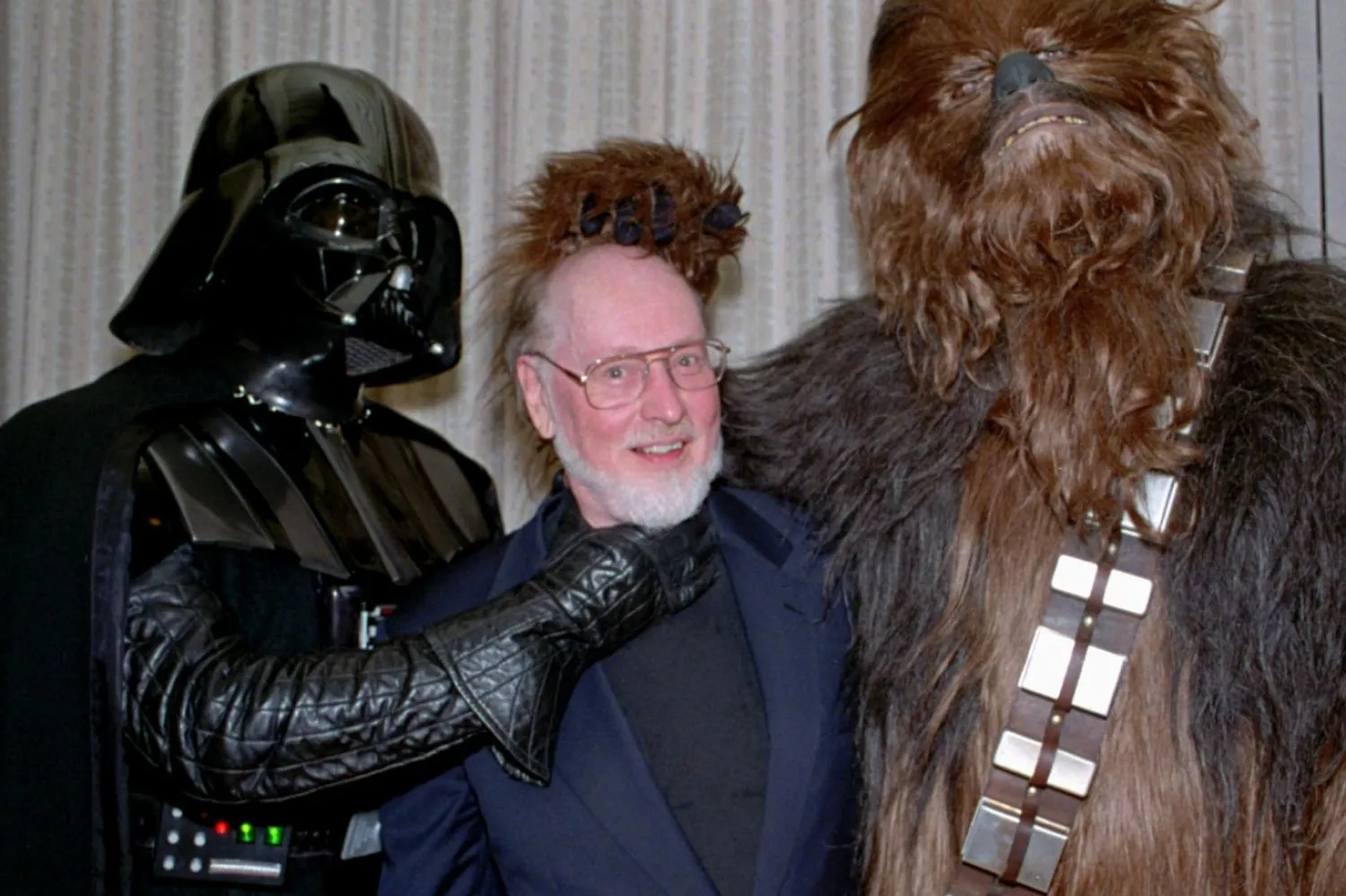 Yıldız Savaşları karakterleri Darth Vader (solda) ve Chewbacca (sağda), gişe canavarı serinin ikonik müziklerine imza atan John Williams'la (ortada) Temmuz 1997'de gerçekleşen bir etkinlikte bir araya gelmişti (AP)