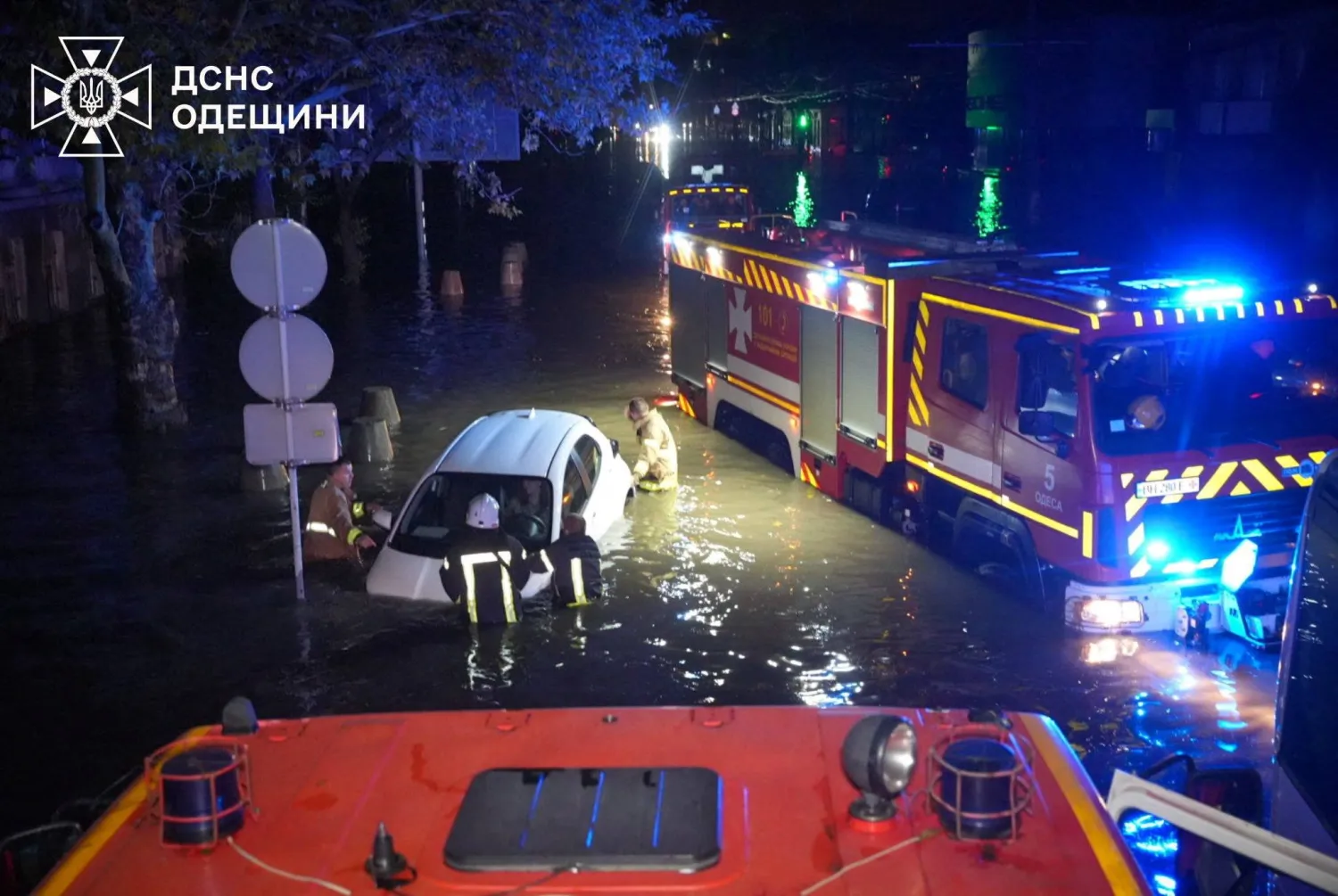 Rescuers push a partially submerged car on a flooded street, following unprecedented rainfall in Odesa, Ukraine in this handout picture released October 1, 2025. Press service of the State Emergency Service of Ukraine in Odesa region/Handout via REUTERS