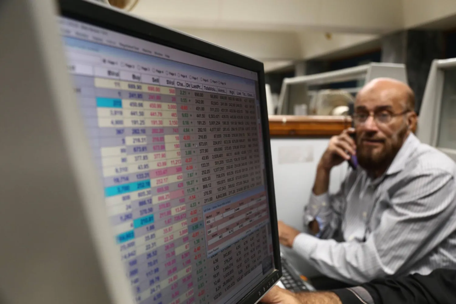 متعامل يراقب الأسهم في بورصة باكستان بكراتشي (إ.ب.أ)