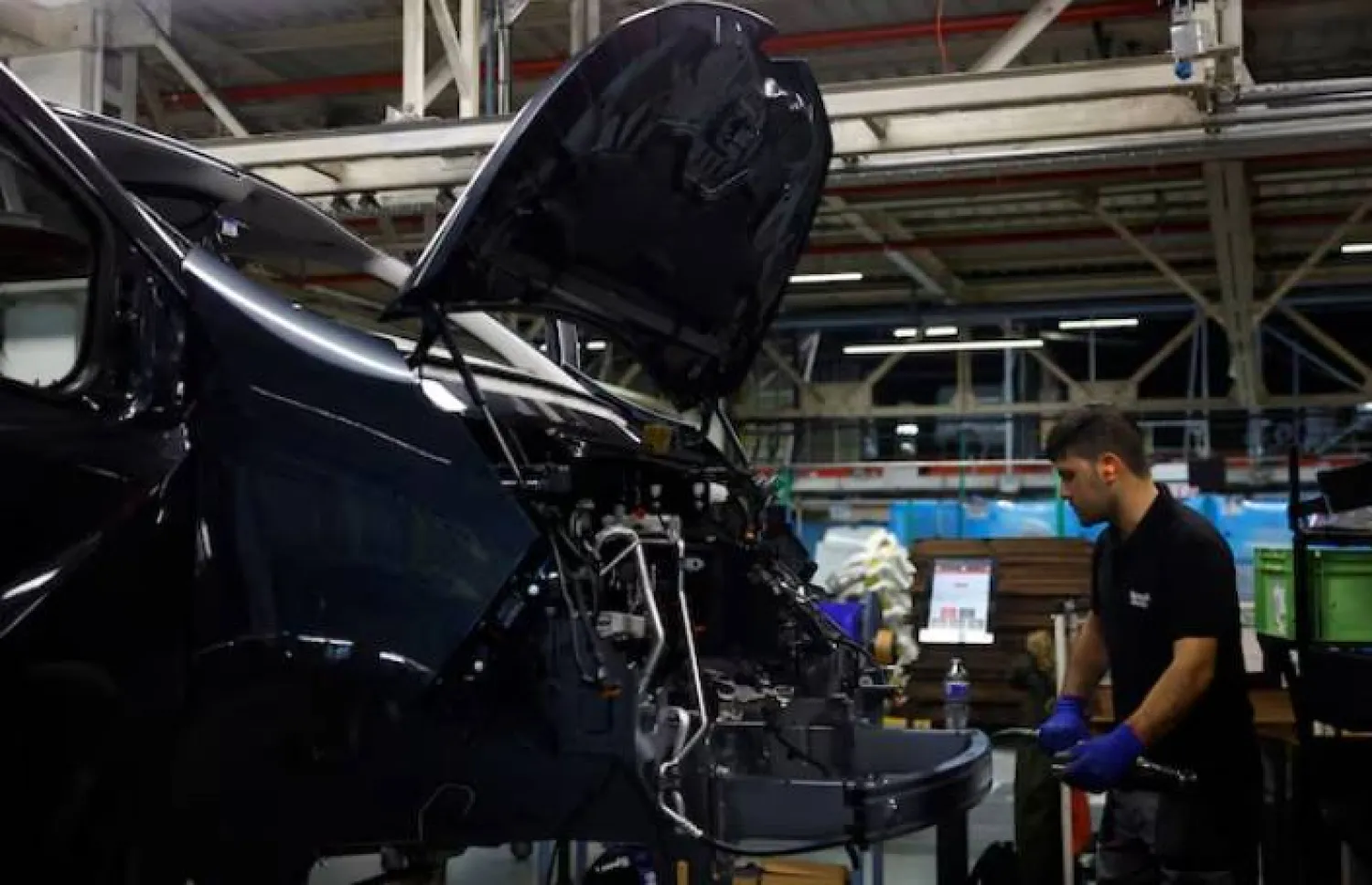 موظف يعمل على خط تجميع سيارات «رينو ترافيك» في مصنع ساندوفيل بفرنسا (رويترز)