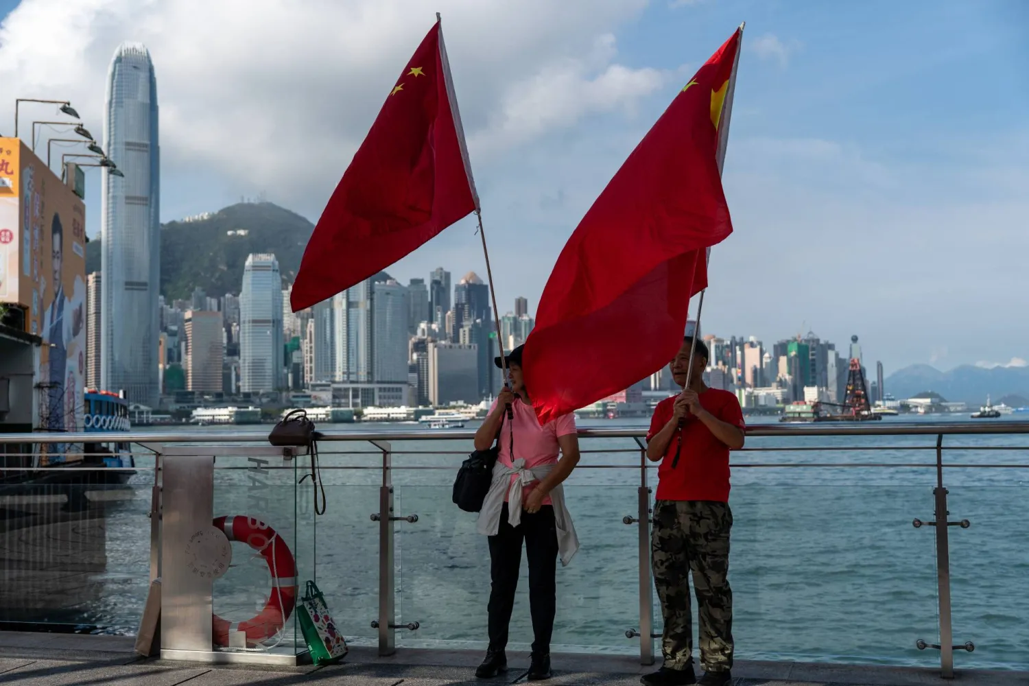 صينيون يُلوِّحون بأعلام البلاد على جزيرة هونغ كونغ في ذكرى الاحتفال باليوم الوطني (د.ب.أ)