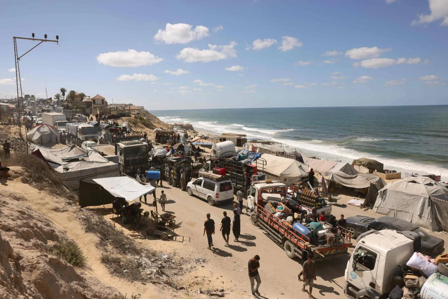 نازحون بأمتعتهم على طريق ساحلي باتجاه الجنوب من وادي غزة بعد إعلان الجيش الإسرائيلي إغلاق طريق الرشيد باتجاه الشمال يوم الأربعاء (أ.ف.ب)