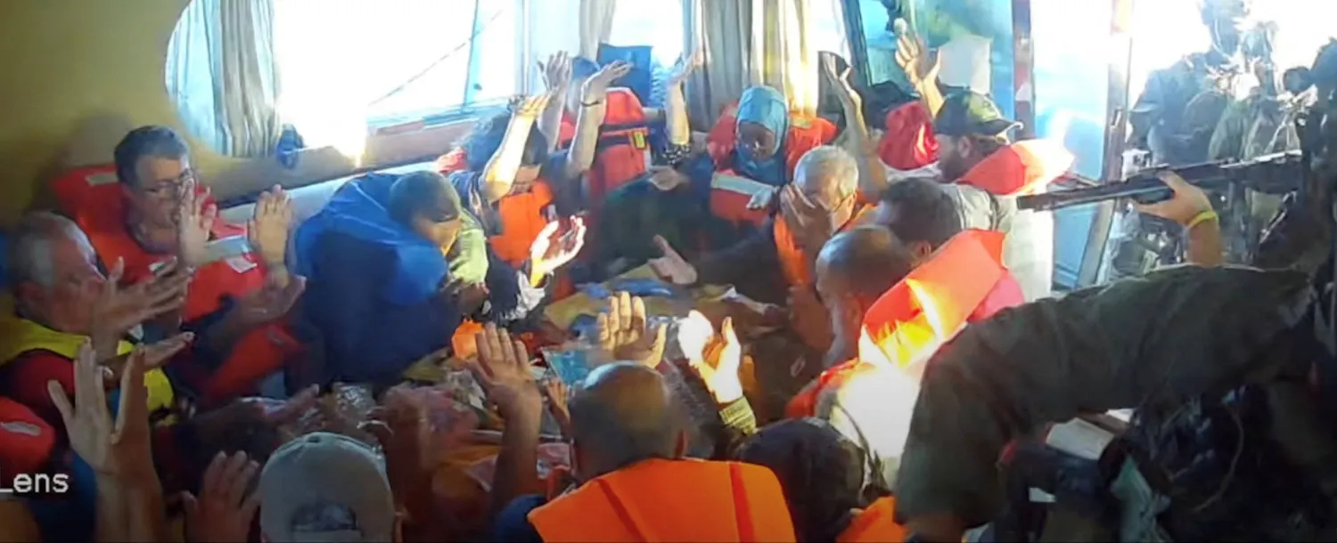 لقطة من فيديو مباشر لأفراد طاقم السفينة «فلوريدا» وهم يرفعون أيديهم بعد أن داهمت قوات البحرية الإسرائيلية السفينة التي كانت متجهة إلى غزة (رويترز)