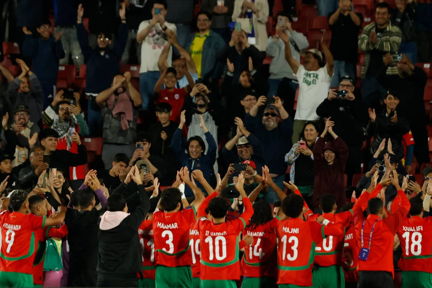 لاعبو المغرب يشاركون الجماهير فرحتهم بالفوز على البرازيل (أ.ف.ب)