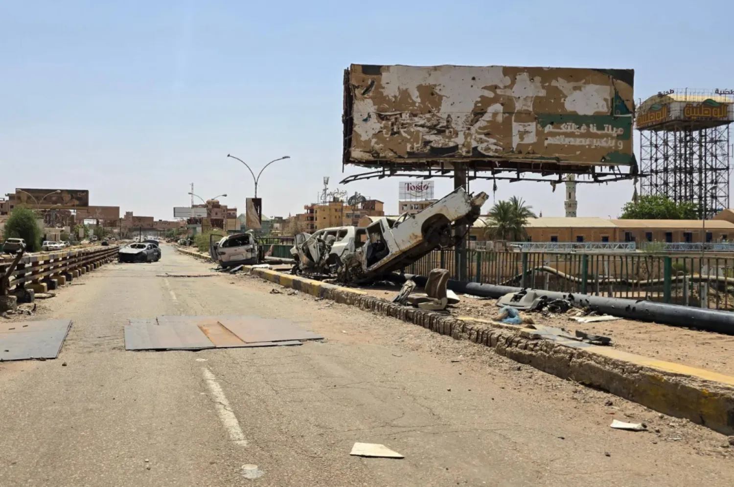 The wreckage of cars lie on the remains of the Shambat Bridge, which connects Omdurman and Bahri, on June 24, 2025 in the Sudanese capital region. (AFP)
