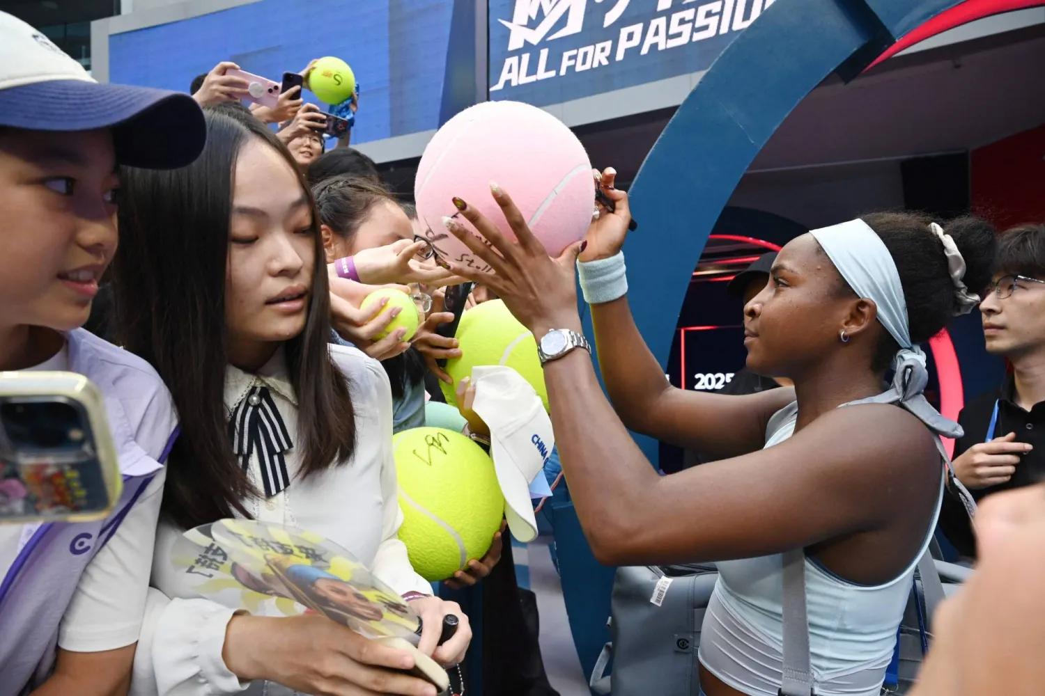 USA's Coco Gauff signs autographs after winning her women's singles quarter-final match against Germany's Eva Lys at the China Open tennis tournament in Beijing on October 2, 2025. (Photo by GREG BAKER / AFP)