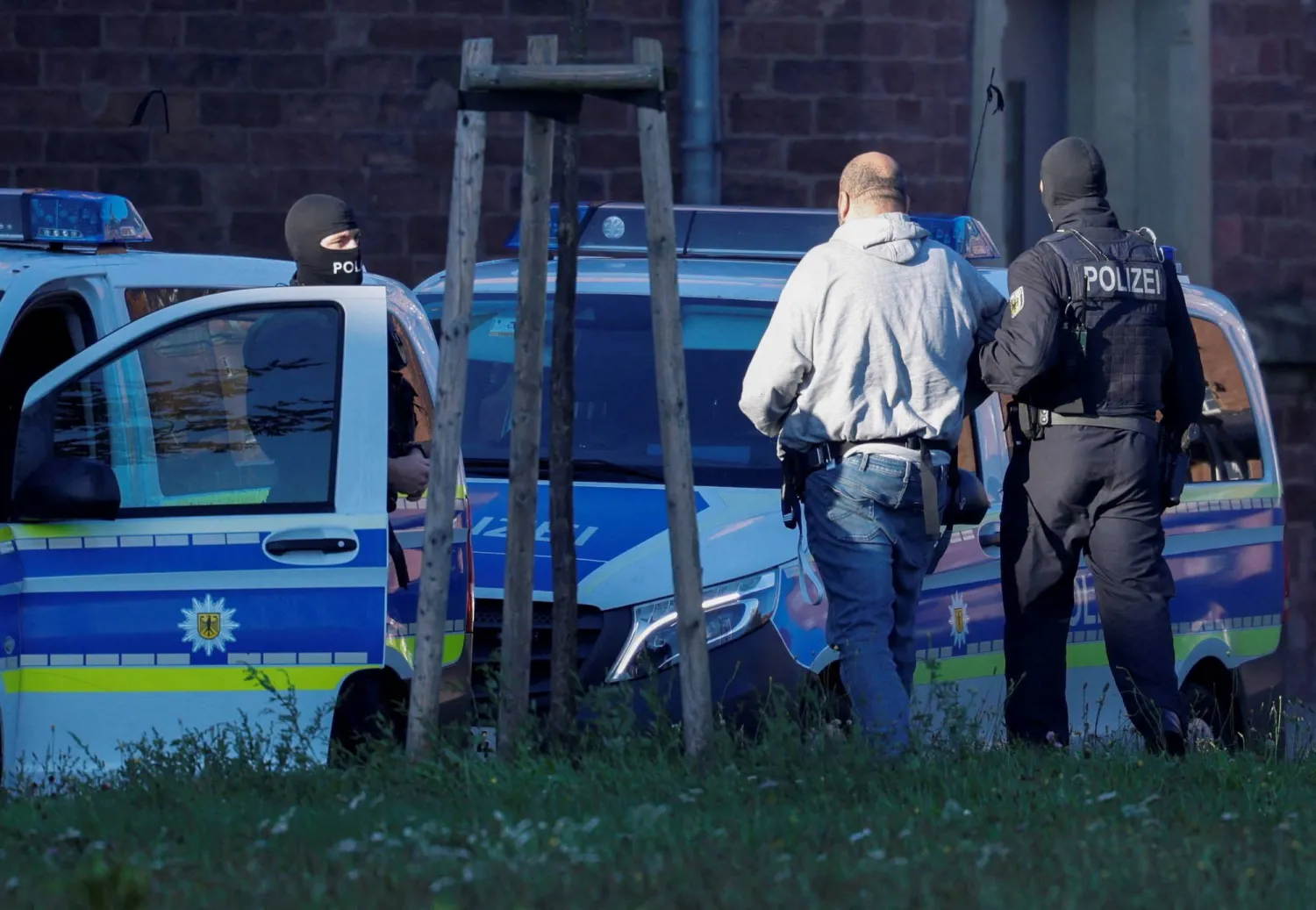 One of the suspected foreign operatives of Hamas, whom authorities believe to have prepared a serious act of violence targeting Israeli or Jewish institutions in Germany, is escorted by police after arriving by helicopter at Germany's German Federal Public Prosecutor in Karlsruhe, Germany, October 2, 2025. REUTERS/Heiko Becker 