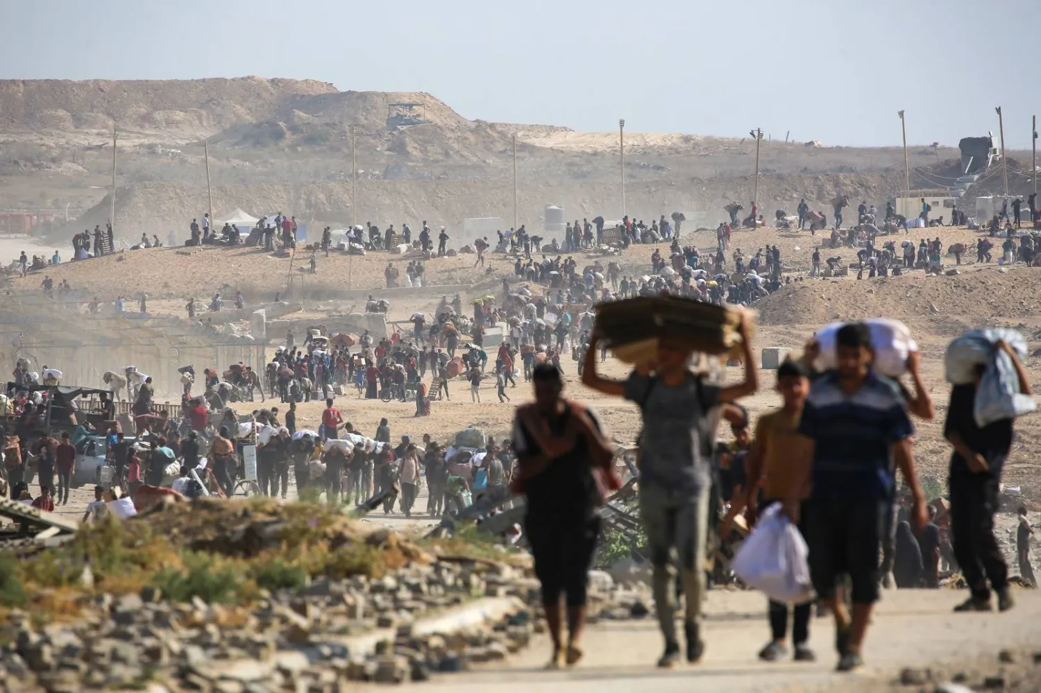 فلسطينيون يحملون مساعدات غذائية جنوب قطاع غزة (أ.ف.ب)