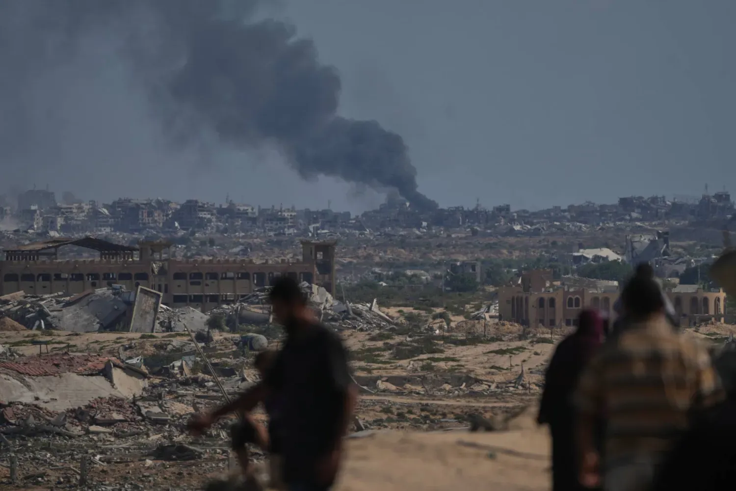 Yerinden edilmiş Filistinliler, İsrail hava saldırısının ardından Gazze şehrinden yükselen dumanı izliyor, 2 Ekim 2025. (AP)