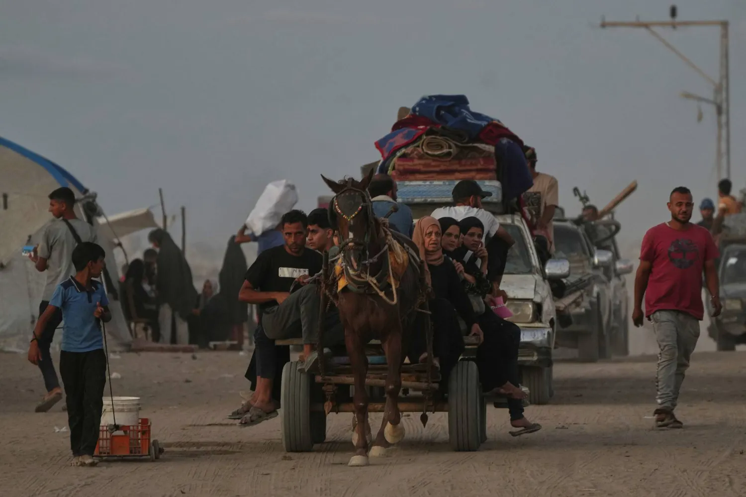 Displaced Palestinians flee northern Gaza carrying their belongings along the coastal road near Wadi Gaza, Wednesday, Oct, 1, 2025. (AP Photo/Abdel Kareem Hana)