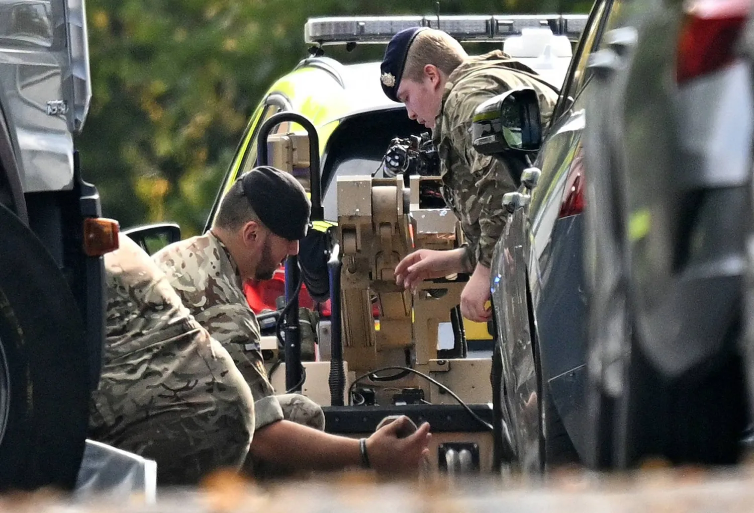 جنديان يشتغلان على جهاز لتفكيك القنابل قرب موقع الهجوم في مانشستر أمس (أ.ف.ب)
