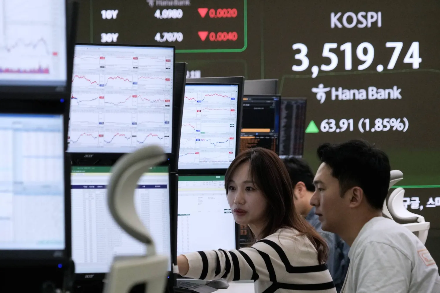 متداولو العملات يتابعون مؤشر «كوسبي» في مقر بنك «هانا» بسيول (أ.ب)