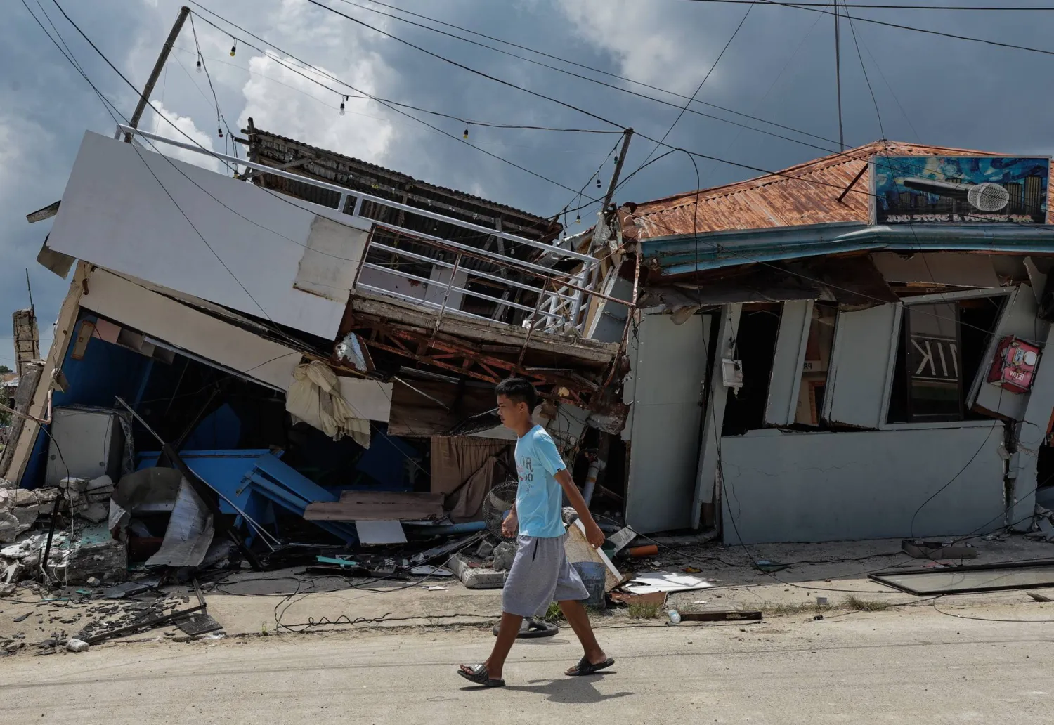 A person walks past collapsed structures in a port area affected by an earthquake in Bogo City, Cebu, Philippines, 03 October 2025. (EPA)