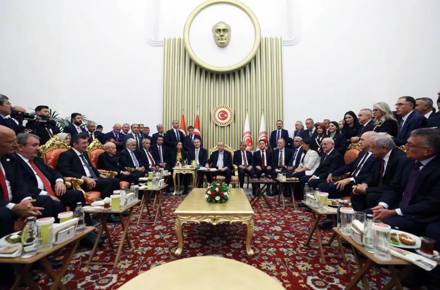 الرئيس التركي رجب طيب إردوغان وإلى جانبه رفيقاه السابقان أحمد داود أوغلو وعلي باباجان خلال حفل استقبال في افتتاح السنة التشريعية الجديدة للبرلمان الأربعاء الماضي (الرئاسة التركية)