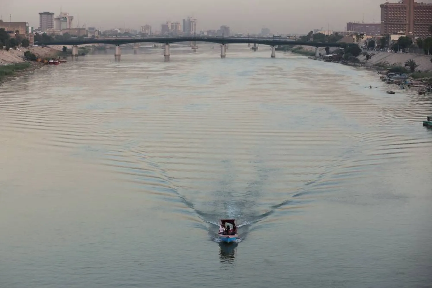 An Iraqi man rides his boat at dusk in the Tigris River in central Baghdad, on September 30, 2025. (AFP) 