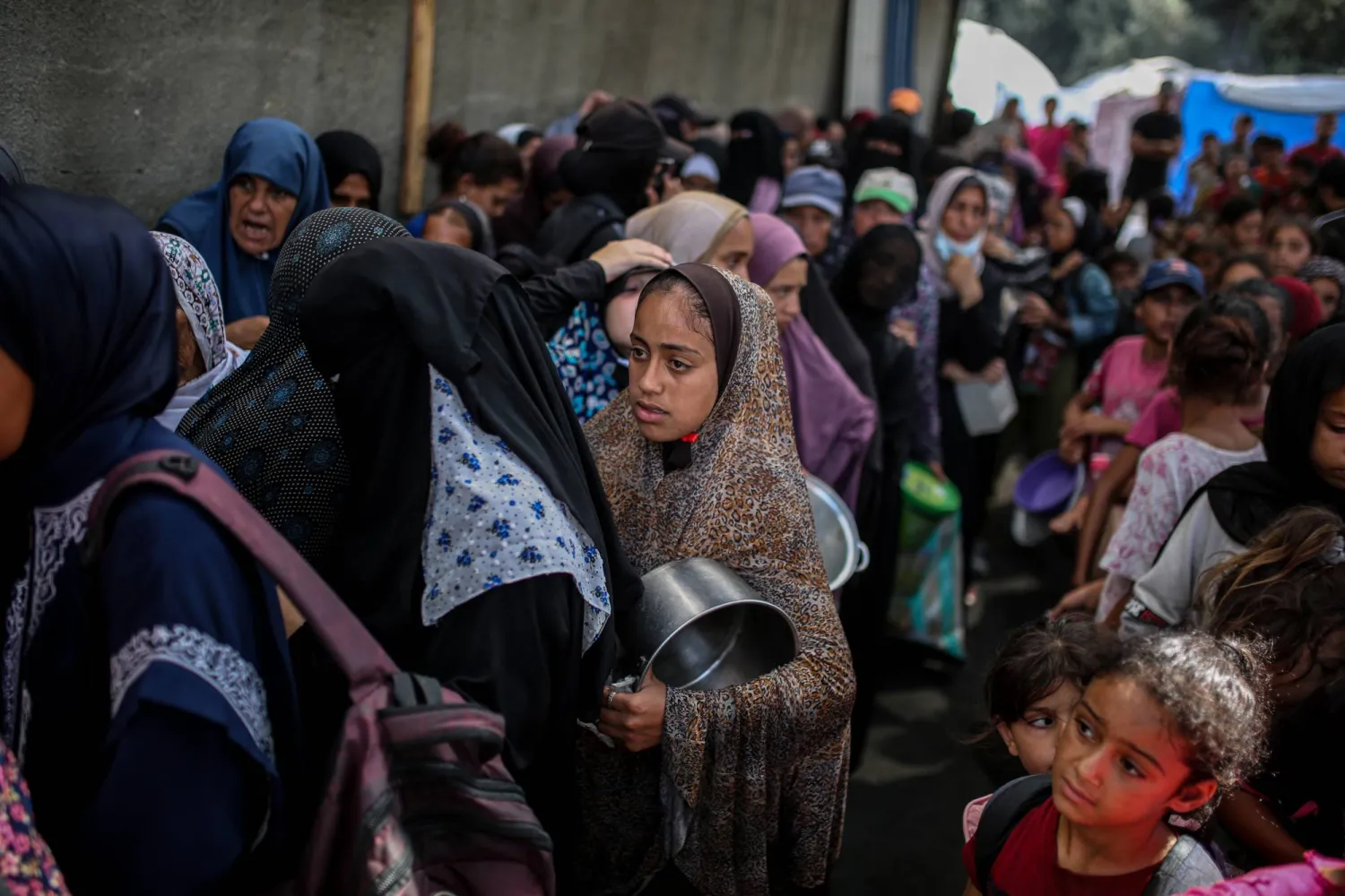فلسطينيون ينتظرون للحصول على وجبة طعام من منظمة خيرية بمخيم النصيرات للاجئين في قطاع غزة السبت (د.ب.أ)