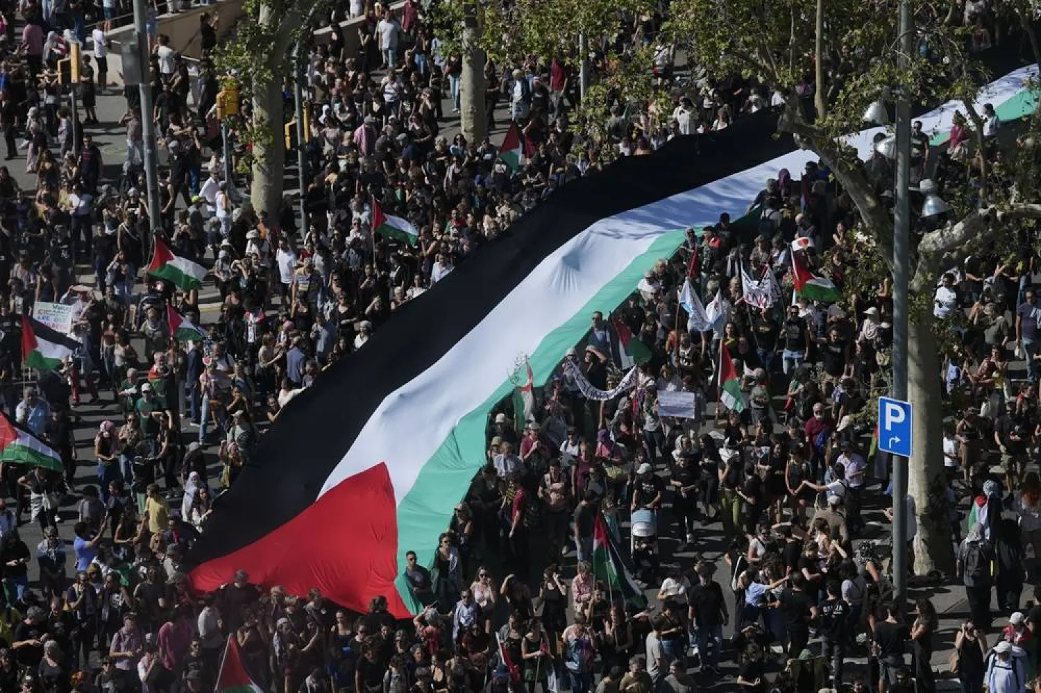 People march with a huge Palestinian flag during a rally organized in support of Palestine in Barcelona, northeastern Spain, 04 October 2025. (EPA)