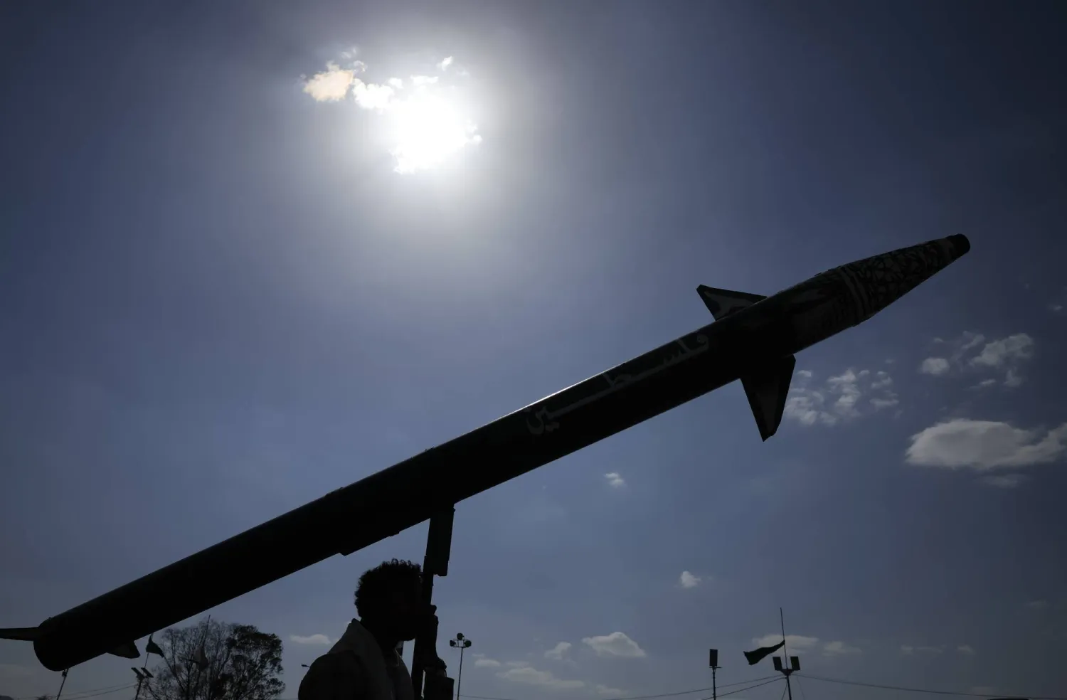 أحد أنصار جماعة الحوثي يحمل نموذجاً لصاروخ في صنعاء باليمن (إ.ب.أ)