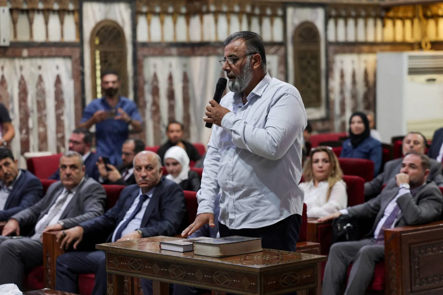 رجل يؤدي اليمين الدستورية أثناء اختيار أعضاء اللجنة الفرعية المشرفة على انتخابات مجلس الشعب السوري (رويترز)