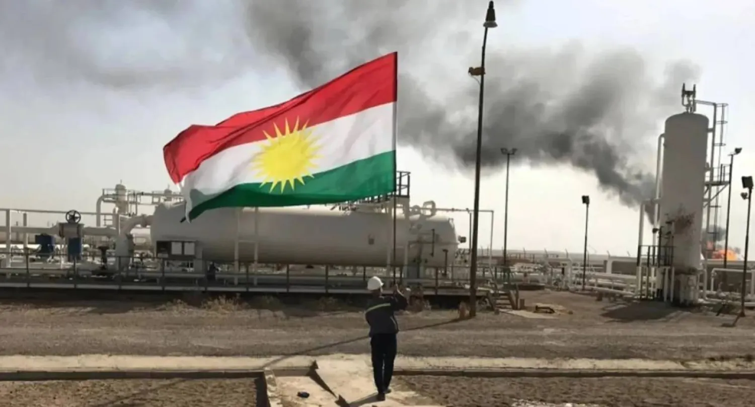 A staff at an oilfield holds the flag of Kurdistan. (X)