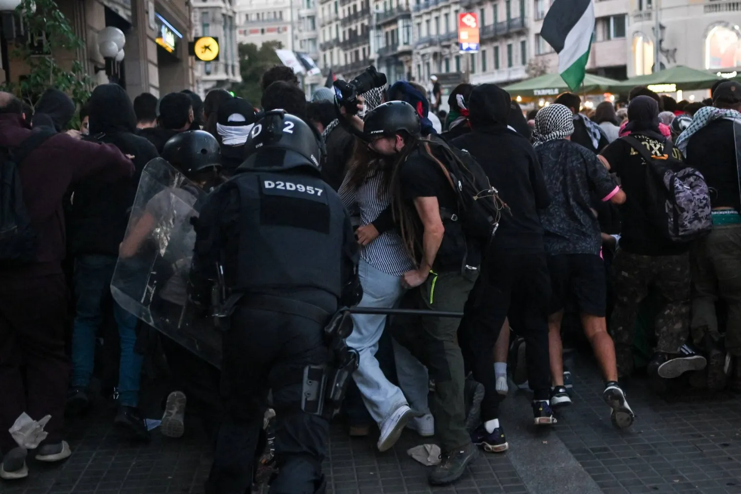 A police officer in riot gear runs after demonstrators during a pro-Palestinian protest condemning Israeli forces' interception of the Global Sumud Flotilla vessels which were aiming to reach Gaza and break Israel's naval blockade, in Barcelona, Spain, October 4, 2025. REUTERS/Lorena Sopena