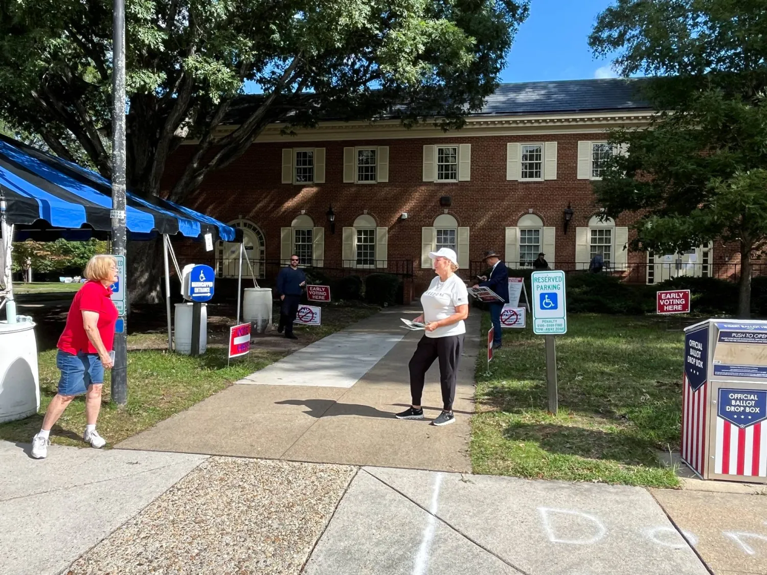 متطوعون يشجعون الناخبين على الإدلاء بأصواتهم في فيرجينيا يوم 2 أكتوبر (رويترز)