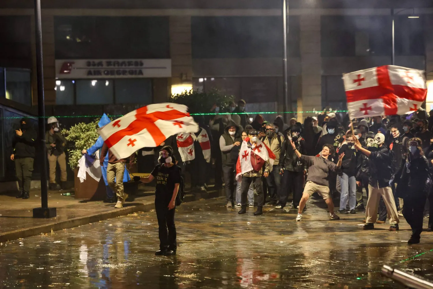 متظاهرون يرفعون الأعلام الجورجية في تبليسي ليلة 5 أكتوبر (أ.ف.ب)