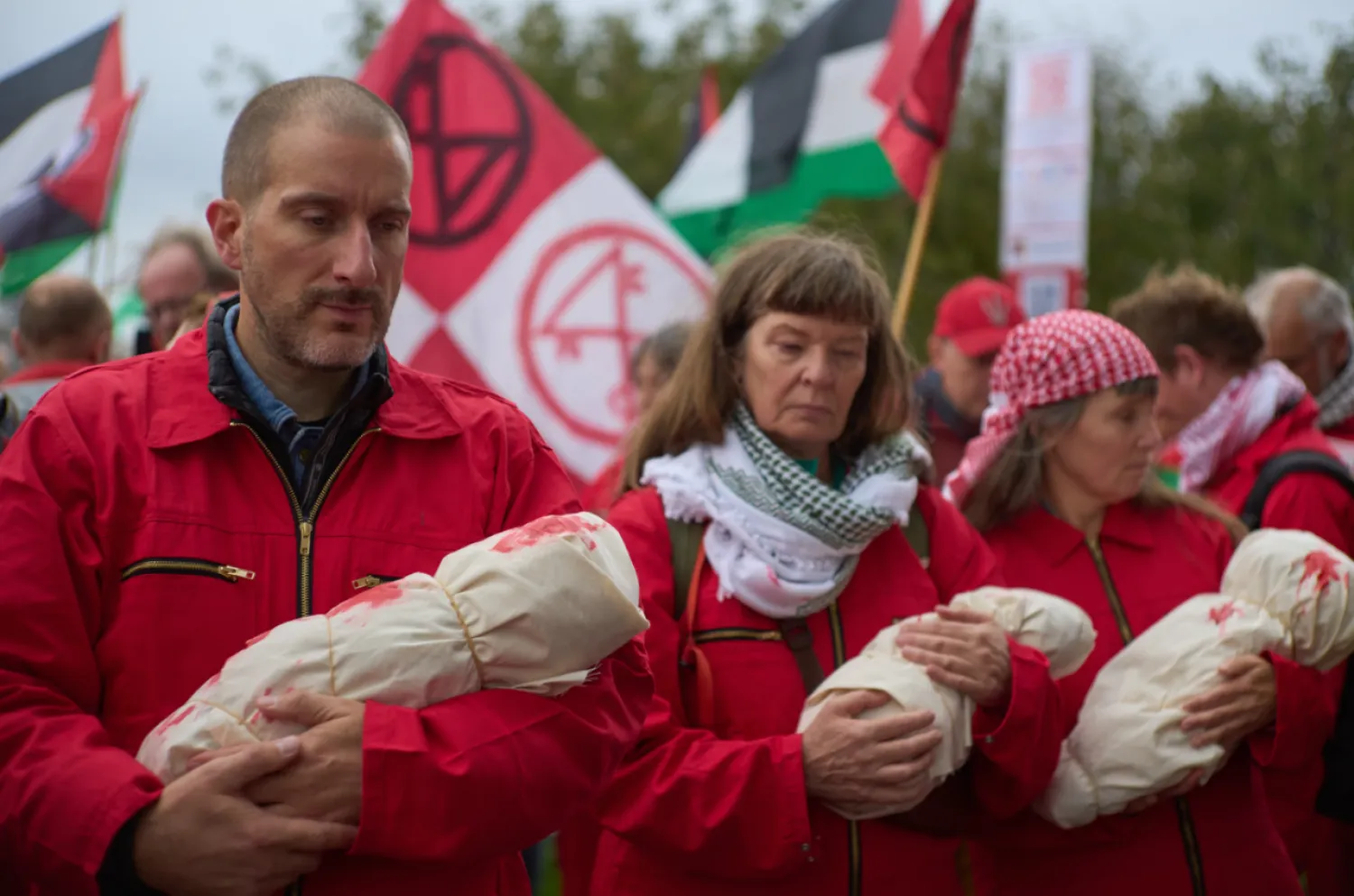 Protesters mimick holding the bodies of children demanding their government do more to halt Israel's campaign in Gaza, during a demonstration in Amsterdam, Netherlands, Sunday, Oct. 5, 2025. (AP Photo/Peter Dejong)