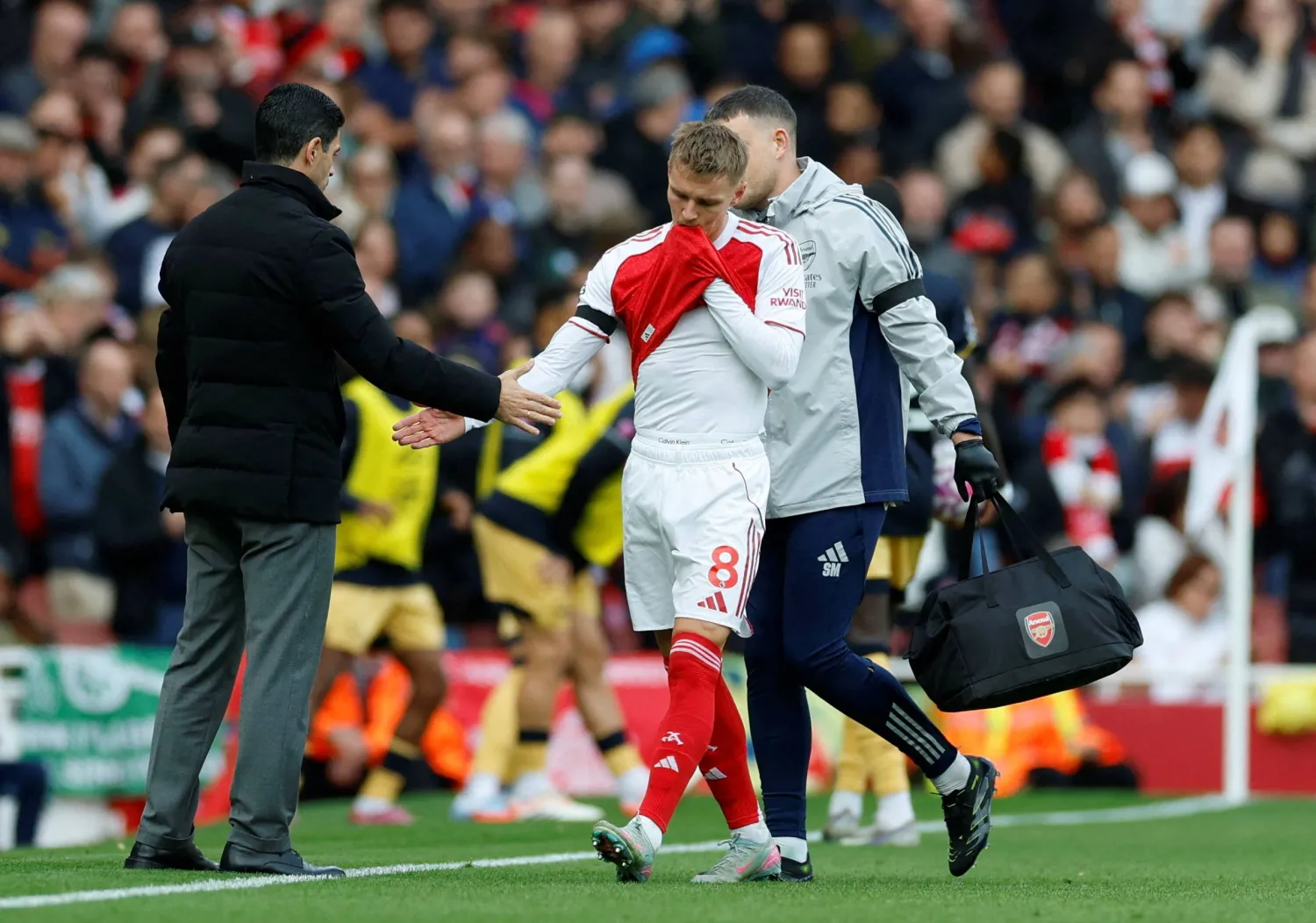 Football - Premier League - Arsenal v West Ham United - Emirates Stadium, London, Britain - October 4, 2025 Arsenal's Martin Odegaard with manager Mikel Arteta after being substituted due to an injury. (Action Images via Reuters/Peter Cziborra)