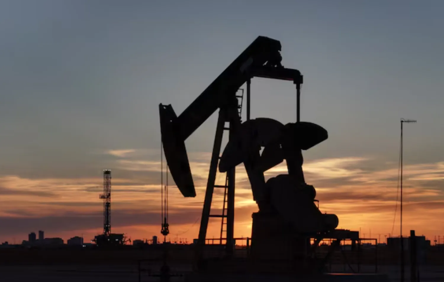 A drone view of a pump jack and drilling rig south of Midland, Texas, US June 11, 2025. REUTERS/Eli Hartman