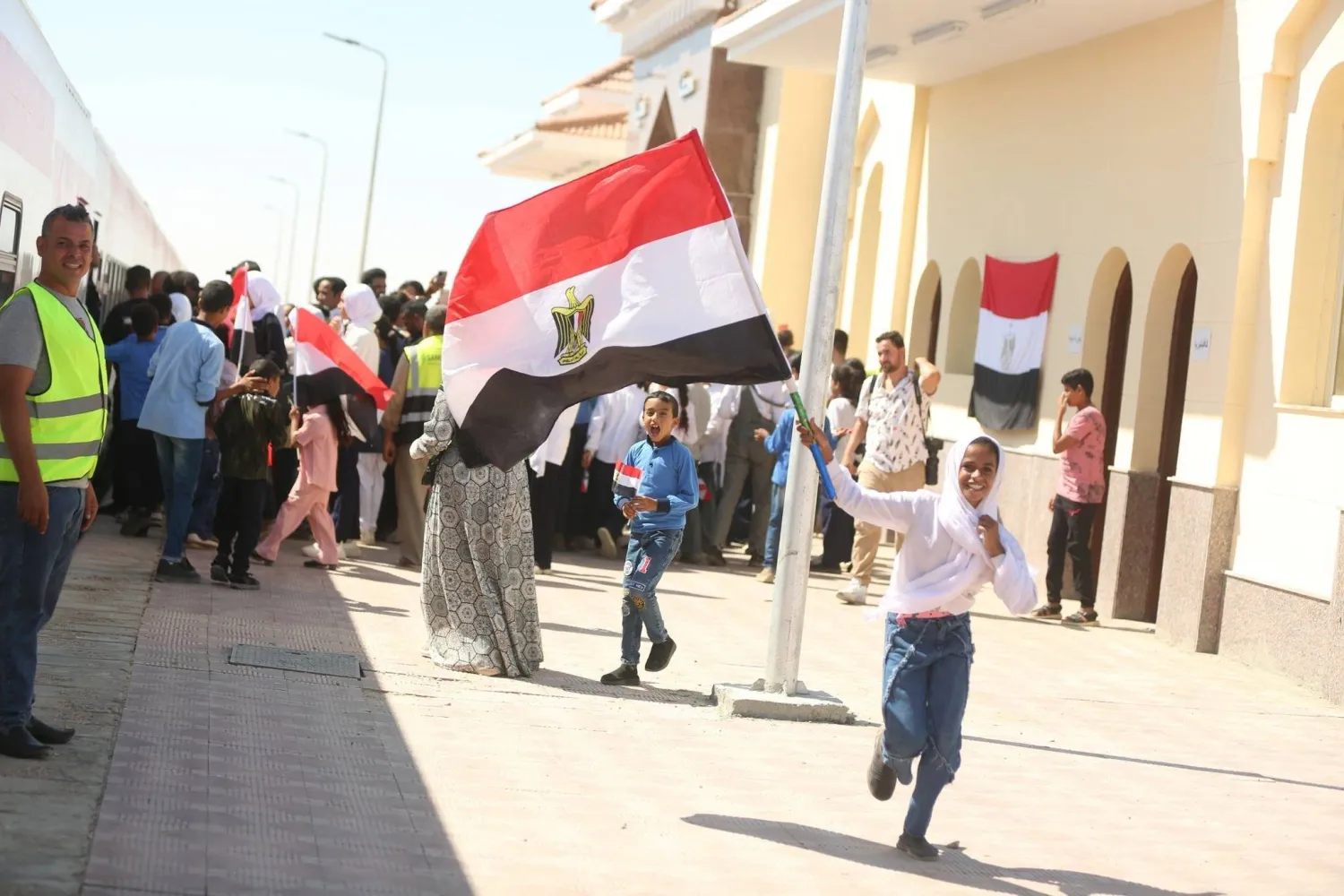 فتاة من أهالي بئر العبد في سيناء ترفع علم مصر فرحة بعودة خط قطار إلى العمل بعد نصف قرن من توقفه (مجلس الوزراء المصري)