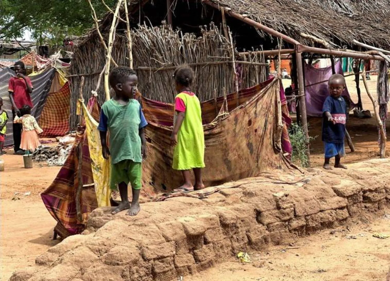 أطفال سودانيون نازحون يقفون في مخيم زمزم بشمال دارفور (رويترز)