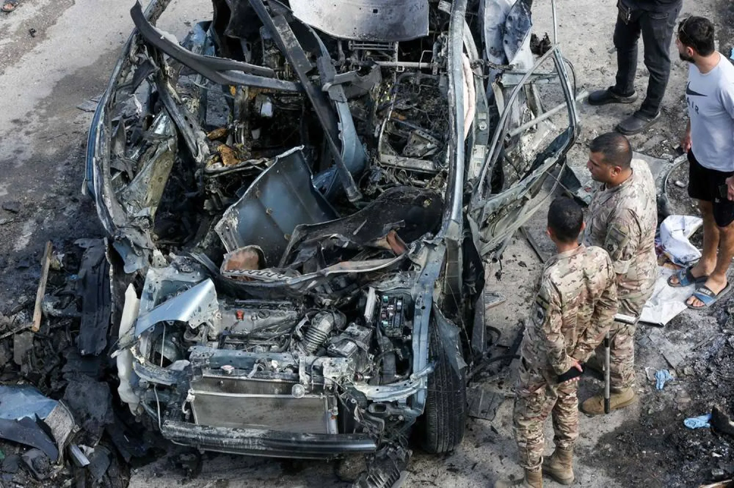 Lebanese security forces inspect a destroyed car targeted in an Israeli drone attack in the southern Lebanese village of Zebdine, on September 6, 2025. (AFP) 