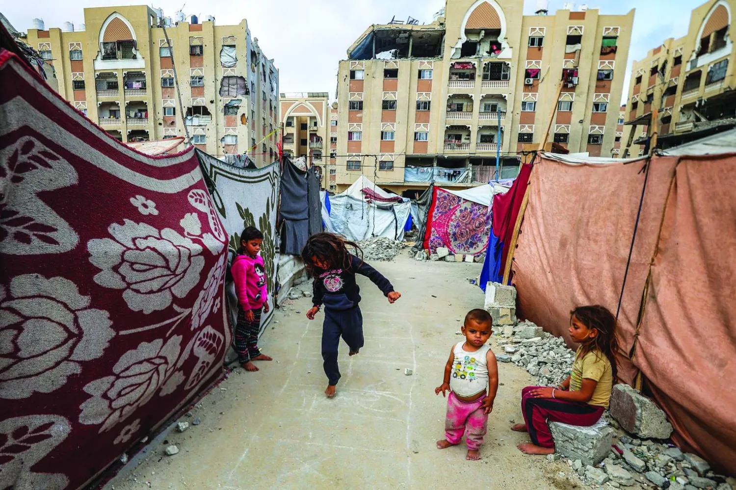 أطفال يلعبون خارج خيام تؤوي نازحين بخان يونس جنوب غزة (أ.ف.ب)