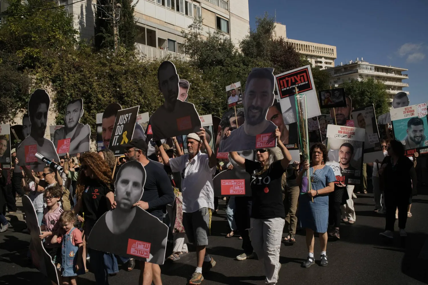 أقارب وأنصار الرهائن الإسرائيليين المحتجزين لدى «حماس» في قطاع غزة يحملون صورهم خلال احتجاج الثلاثاء يطالب بالإفراج الفوري عنهم ويدعو إلى وقف إطلاق النار (أ.ب)