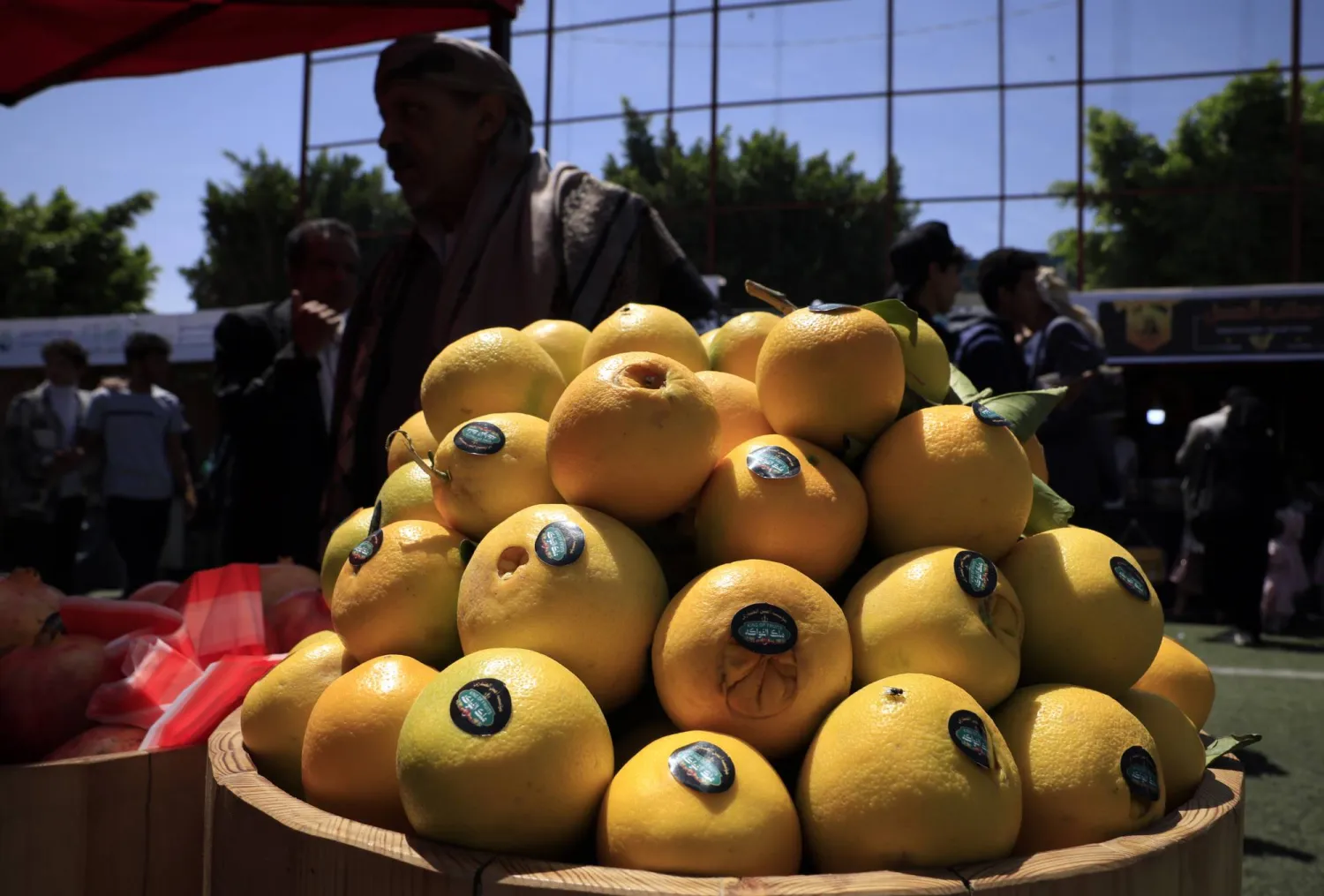 رجل بيع البرتقال ضمن معرض للفاكهة (إ.ب.أ)