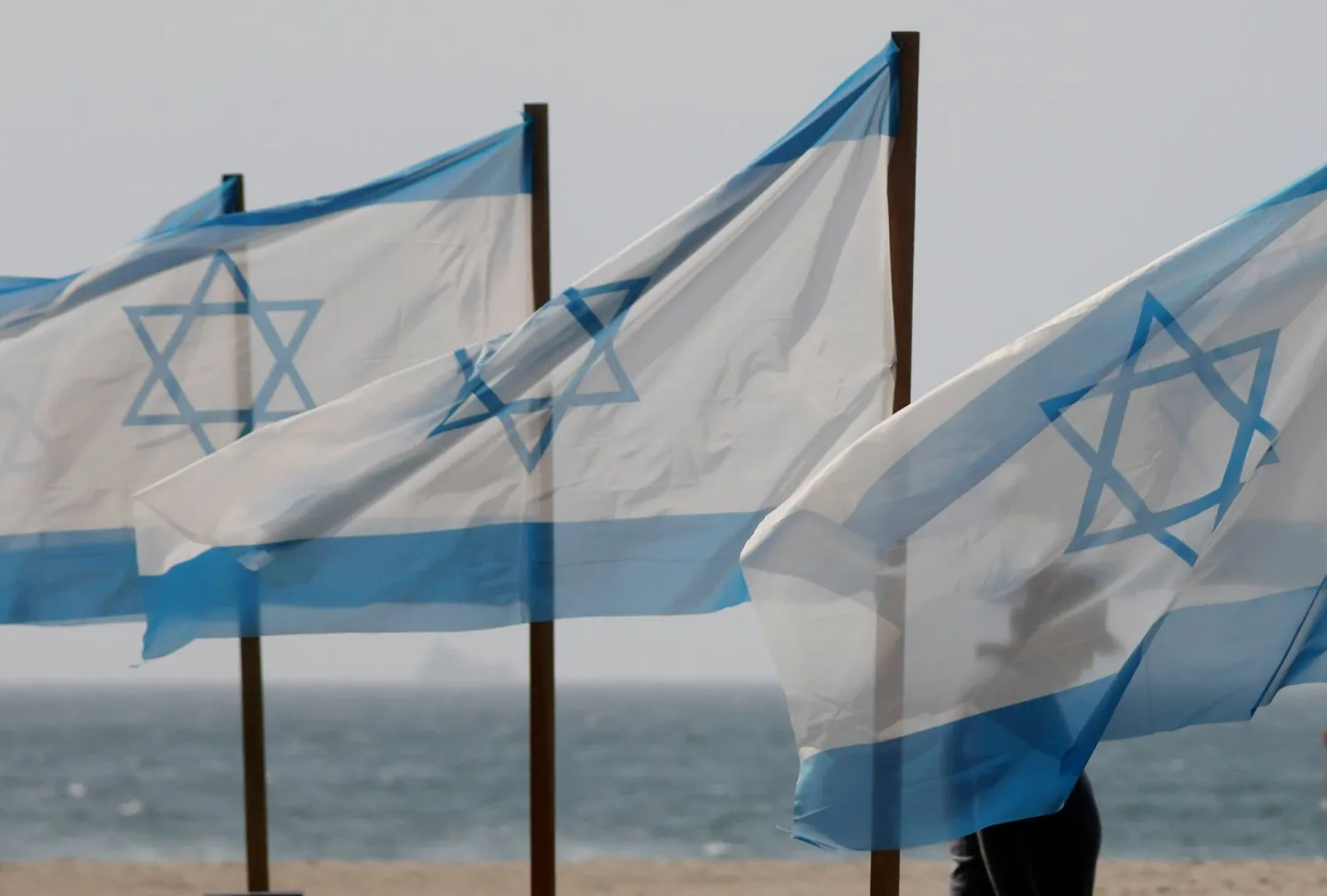 07 October 2025, Brazil, Rio de Janeiro: Rio de Paz, a Brazilian human rights NGO known for its symbolic public demonstrations installs 22 Israeli flags and photos of 48 hostages on Copacabana Beach in a demonstration against terrorism and in solidarity with the victims of the Hamas attack on October 7, 2023, marking two years since the attacks on Israel. (dpa)