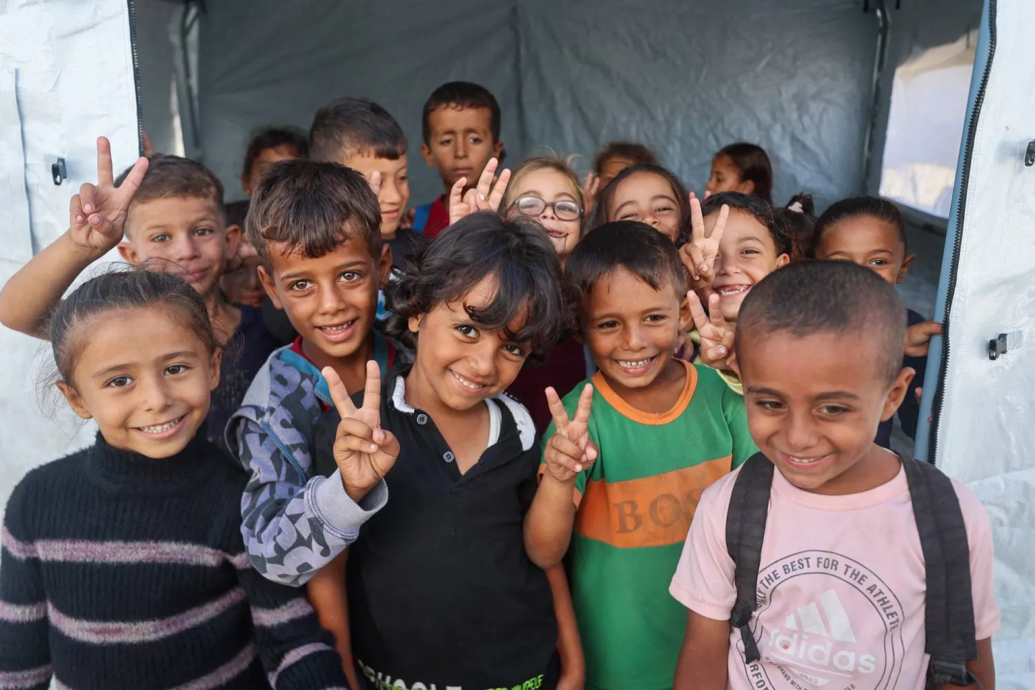 تلاميذ فلسطينيون أمام مدخل خيمة تُستخدم فصلاً دراسياً في مدرسةٍ بخان يونس جنوب قطاع غزة أمس (أ.ف.ب)
