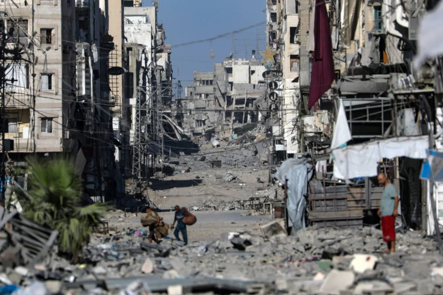 Palestinians move on the damaged Al-Nassr street during an Israeli military operation in Gaza City, Gaza Strip, 07 October 2025. (EPA)