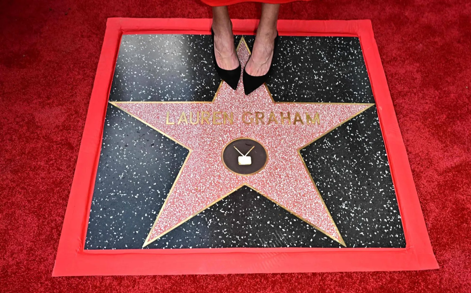 US actress Lauren Graham (detail shoes) stands on her newly unveiled star on the Hollywood Walk of Fame during a ceremony in Hollywood, California, on October 3, 2025. (Photo by Frederic J. BROWN / AFP)