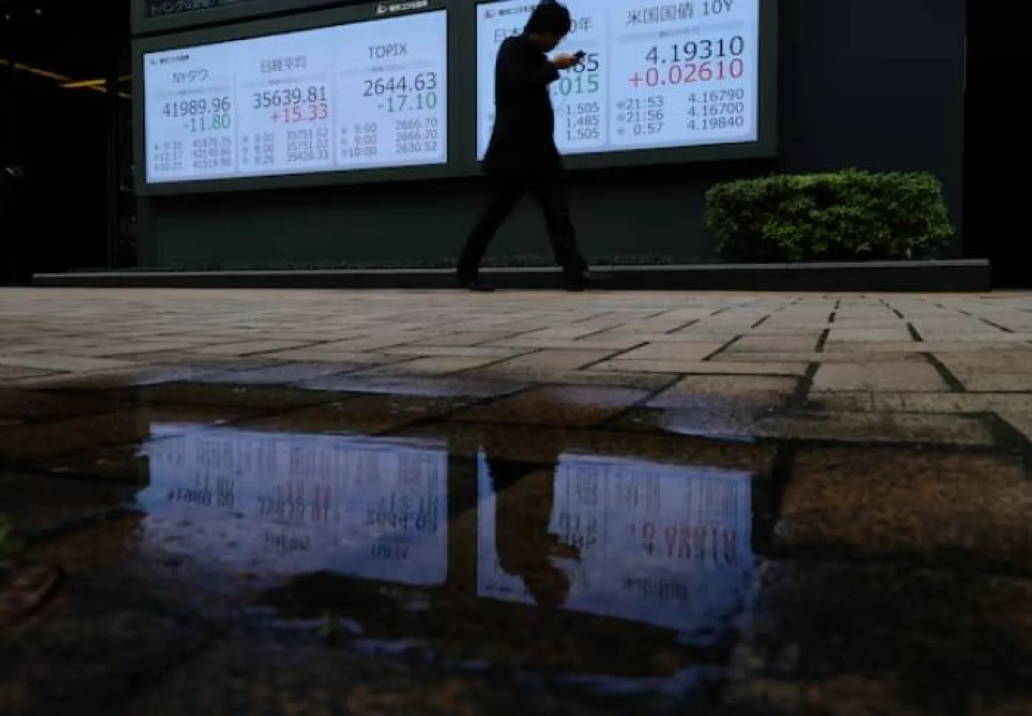 رجل يمر أمام لوحة مؤشرات الأسهم والسندات في طوكيو باليابان خلال أبريل 2025 (رويترز)