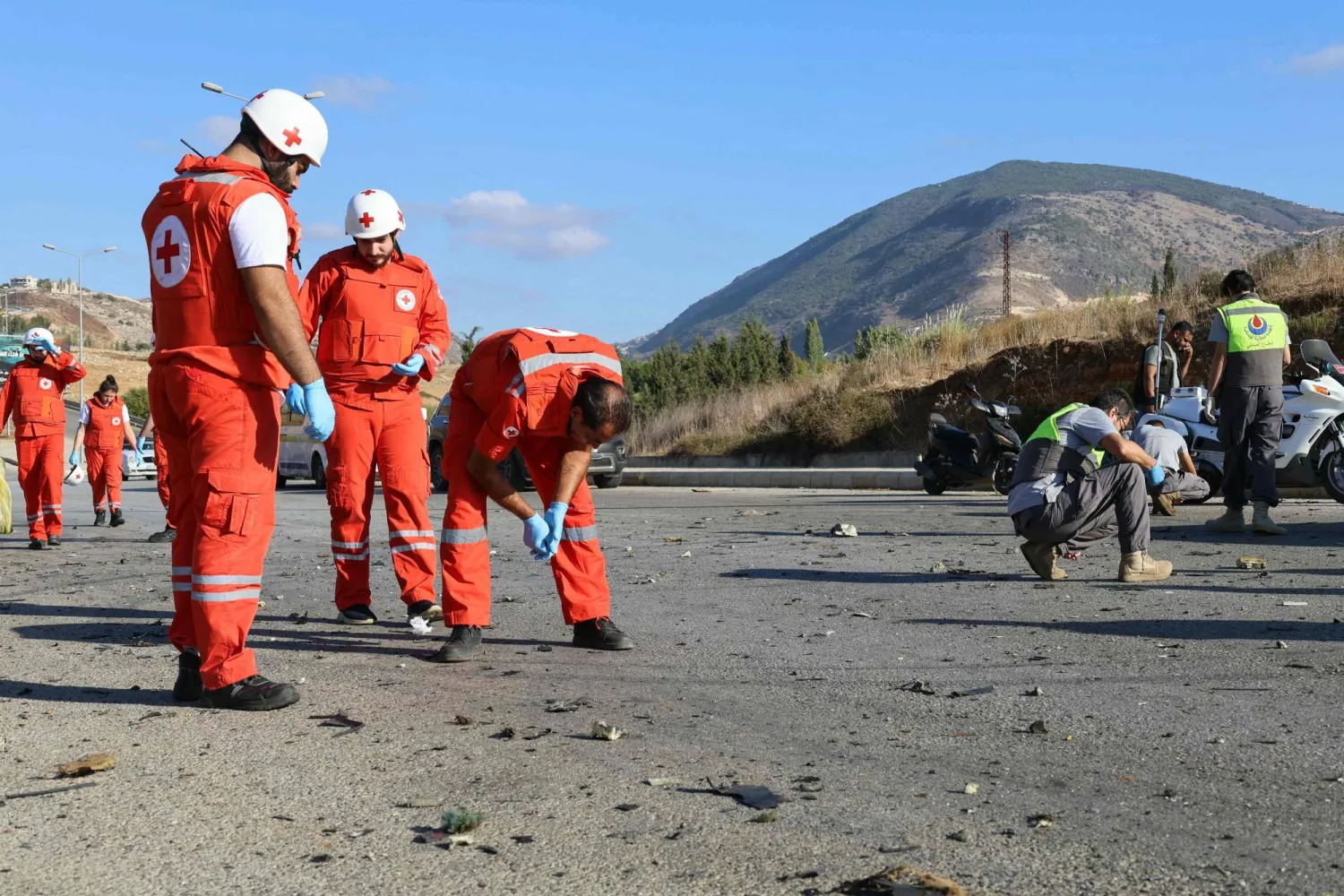 عناصر من «الصليب الأحمر» يجمعون بقايا أشلاء بعد استهداف إسرائيلي لسيارة بمحيط مدينة النبطية بجنوب لبنان الأسبوع الماضي (أ.ف.ب)