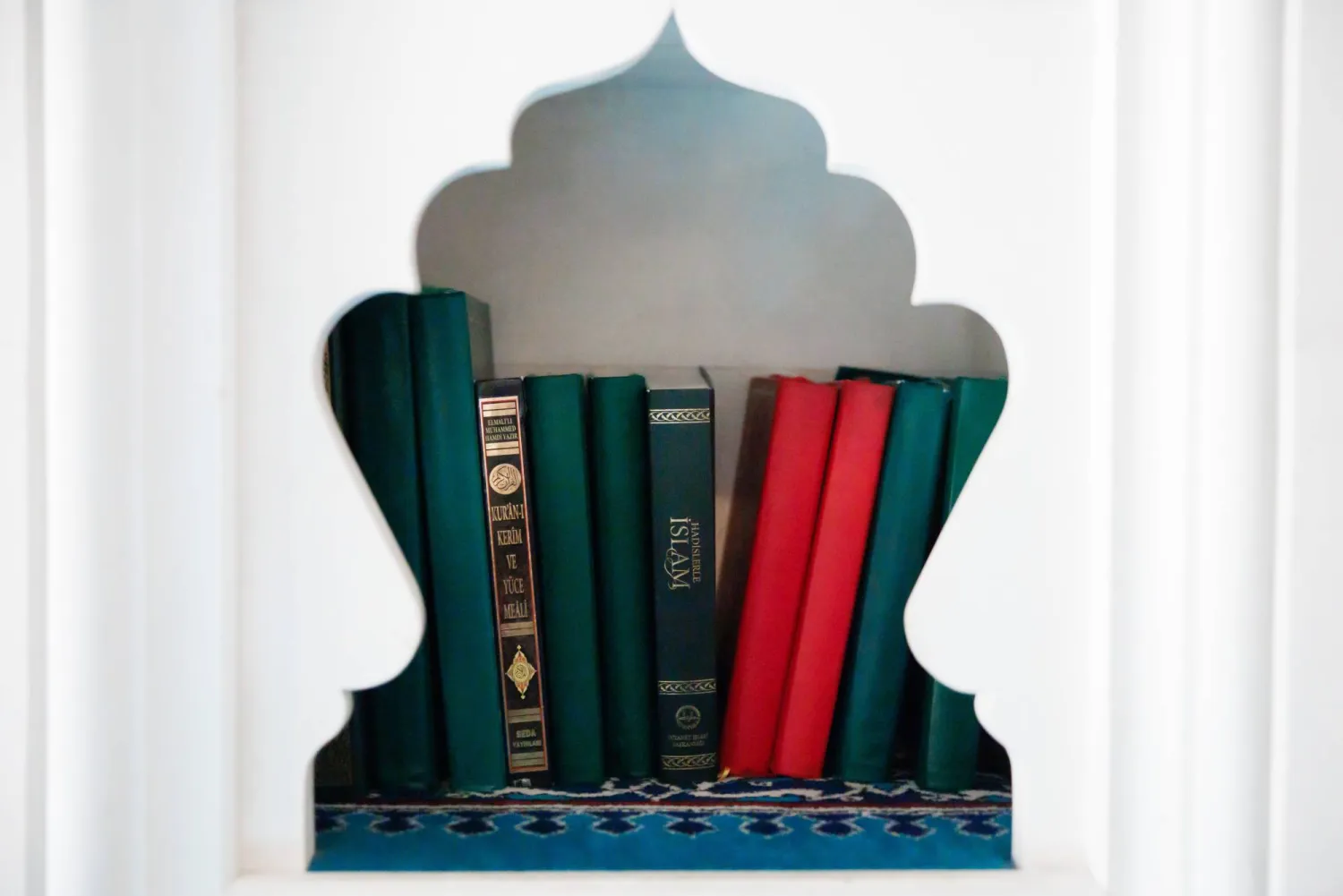 كُتب من بينها القرآن الكريم معروضة على رف في مسجد شهيتليك التابع للاتحاد التركي الإسلامي للشؤون الدينية (ديتيب) خلال يوم المسجد المفتوح في برلين بألمانيا 3 أكتوبر 2025 (إ.ب.أ)