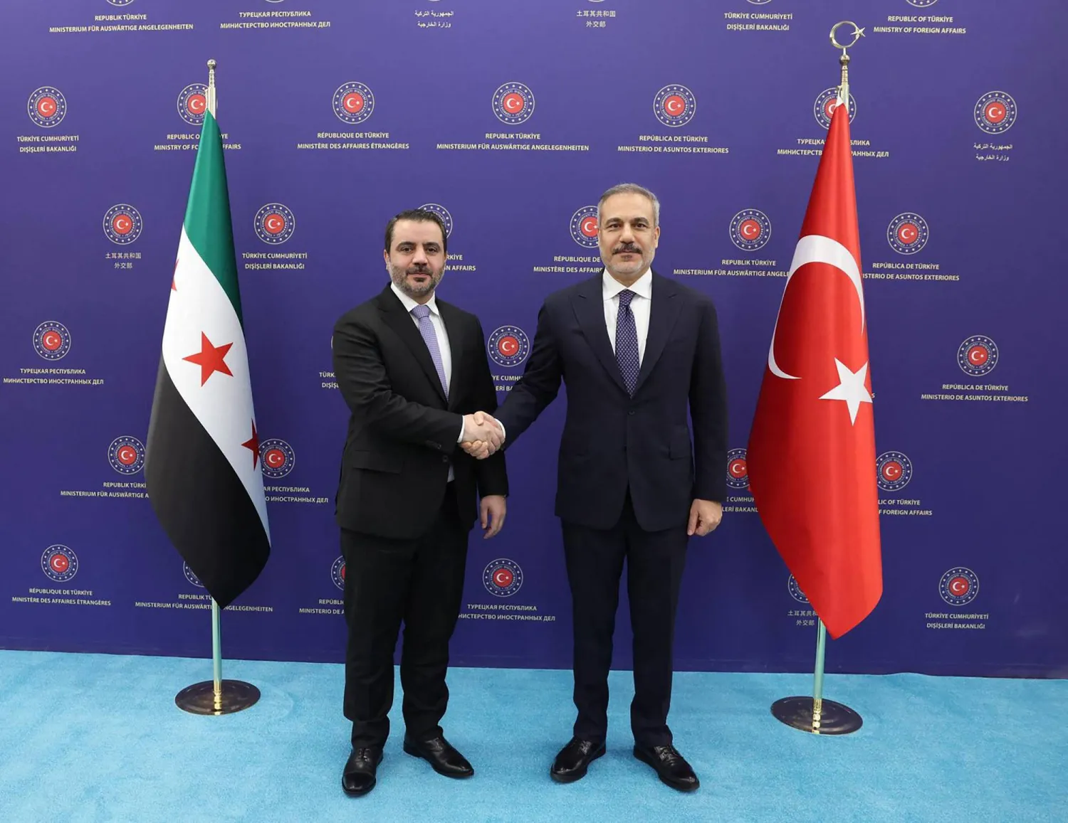 وزير الخارجية التركي هاكان فيدان (يمين) يصافح نظيره السوري أسعد الشيباني في أنقرة اليوم (أ.ف.ب)