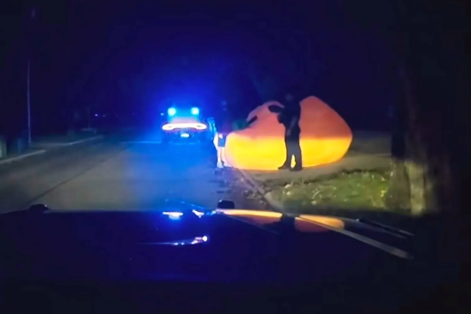 This image made from a Parma Heights Police Department body camera video shows a police officer approaching a runaway inflatable pumpkin on Tuesday, Oct. 7, 2025. (Parma Heights Police Department via AP)