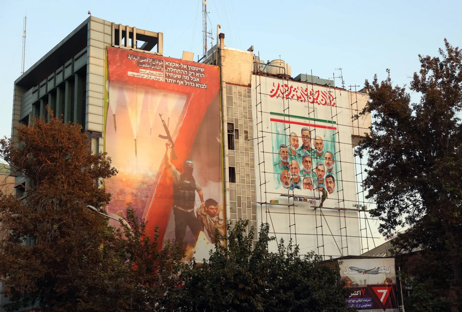 لافتة تحمل صورة قادة إيرانيين قُتلوا في الحرب الأخيرة وأخرى مناهضة لإسرائيل فوق مركز إعلامي معني بفلسطين وسط طهران (إ.ب.أ)