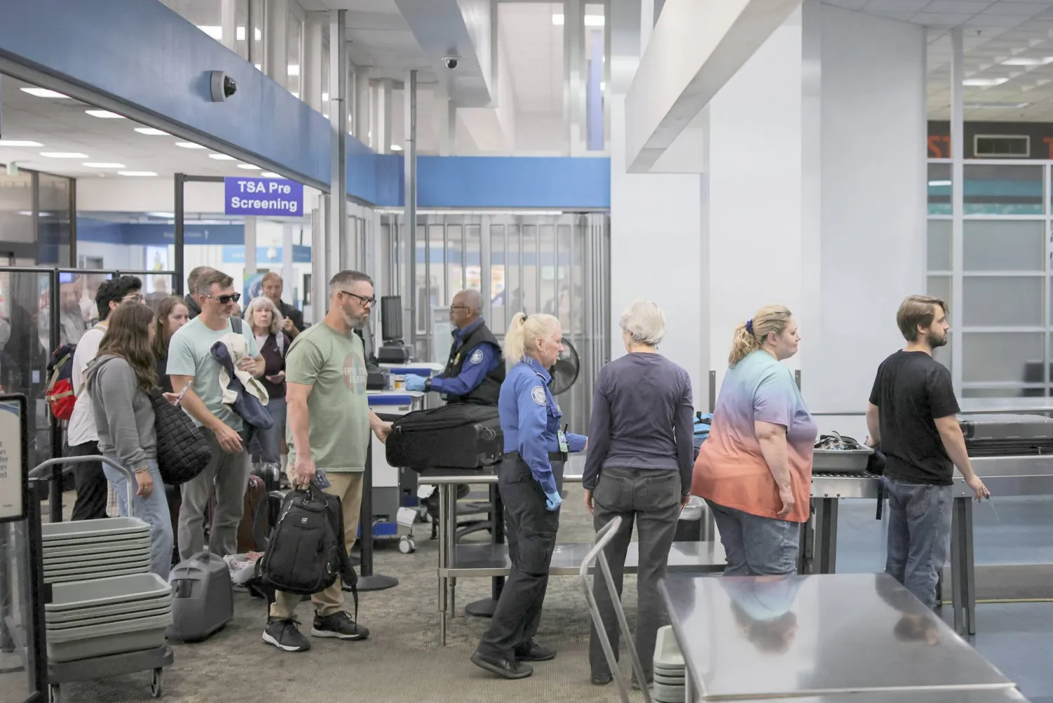 
مسافرون يقفون في صفوف تفتيش طويلة بسبب الإغلاق الحكومي (رويترز)